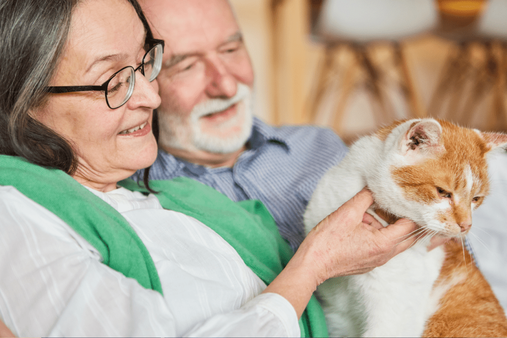 Two seniors holding a cat